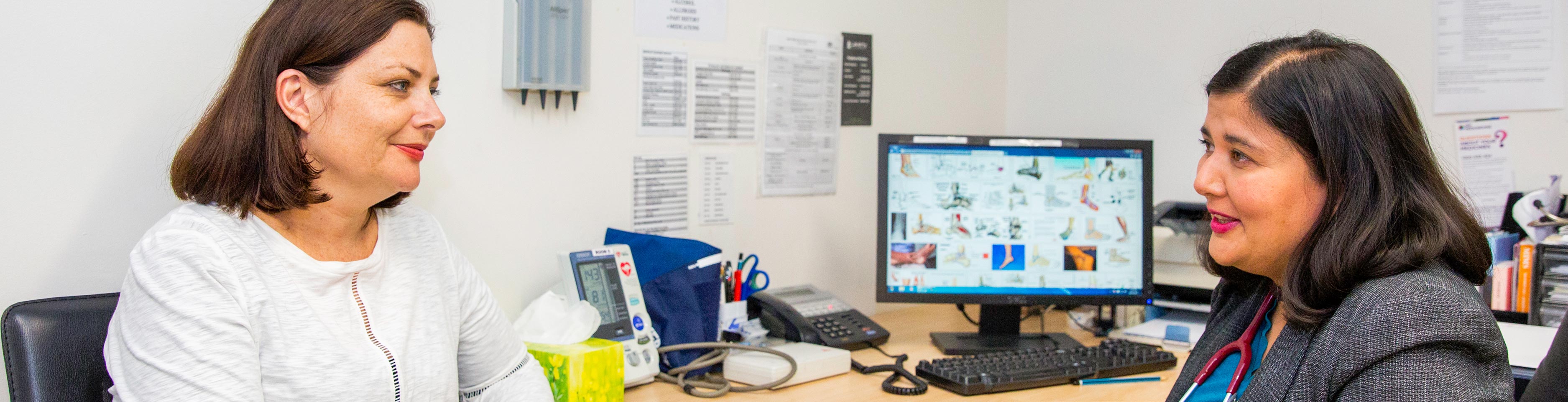 Female doctor speaks to female patient