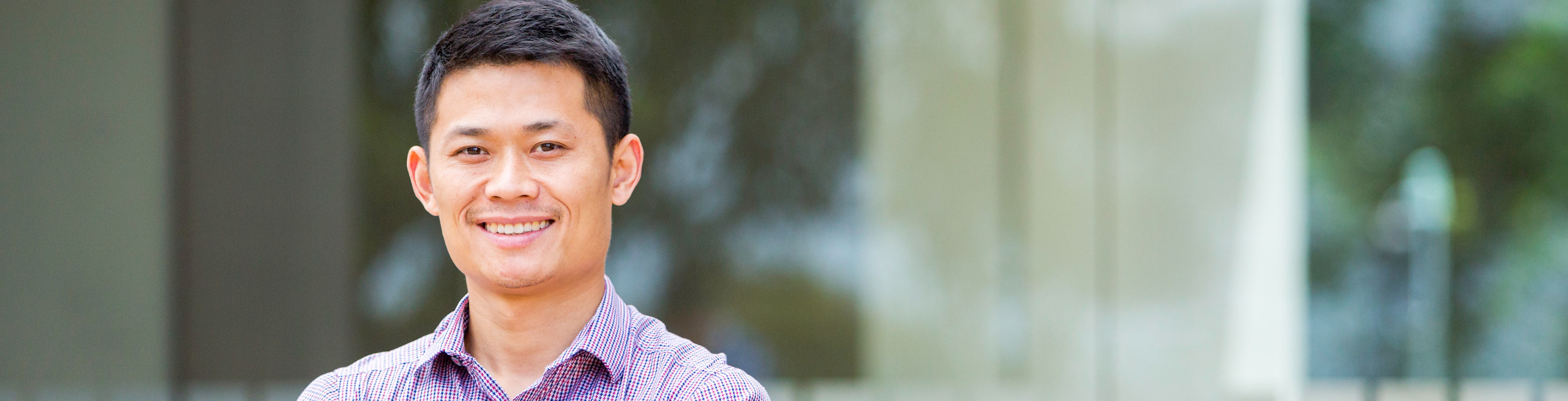 A man in a pink shirt is smiling